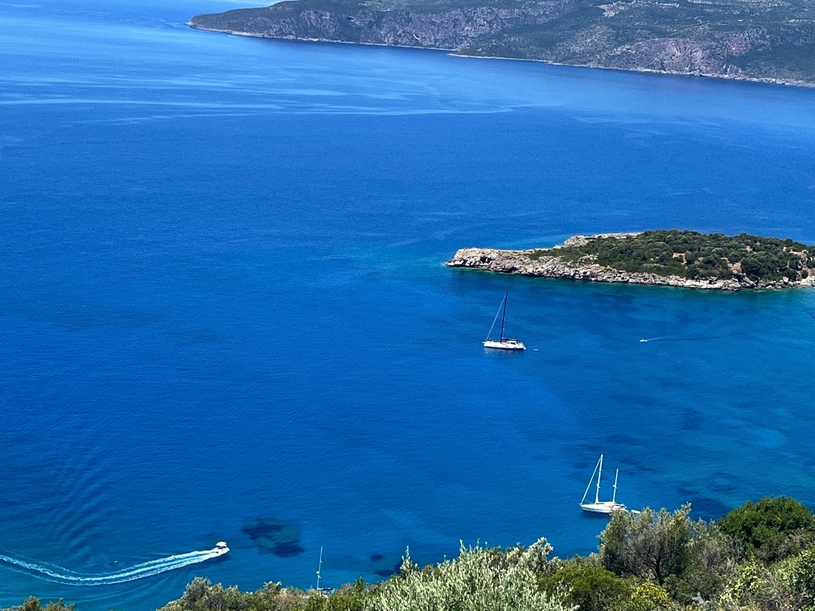 The islet off Kalamitsi with yachts at anchor in the clear water.