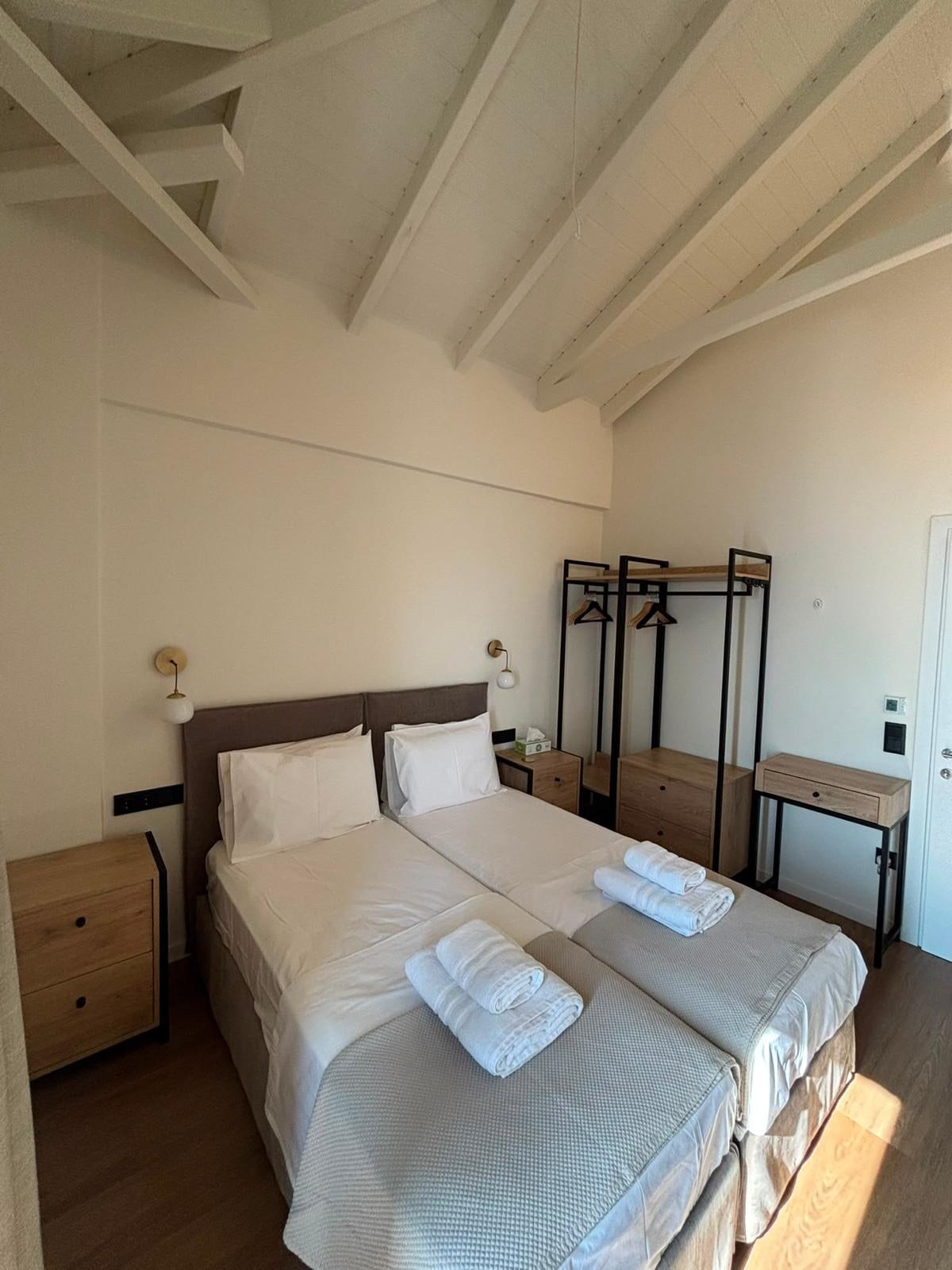 Twin beds under the beams on the upper floor.