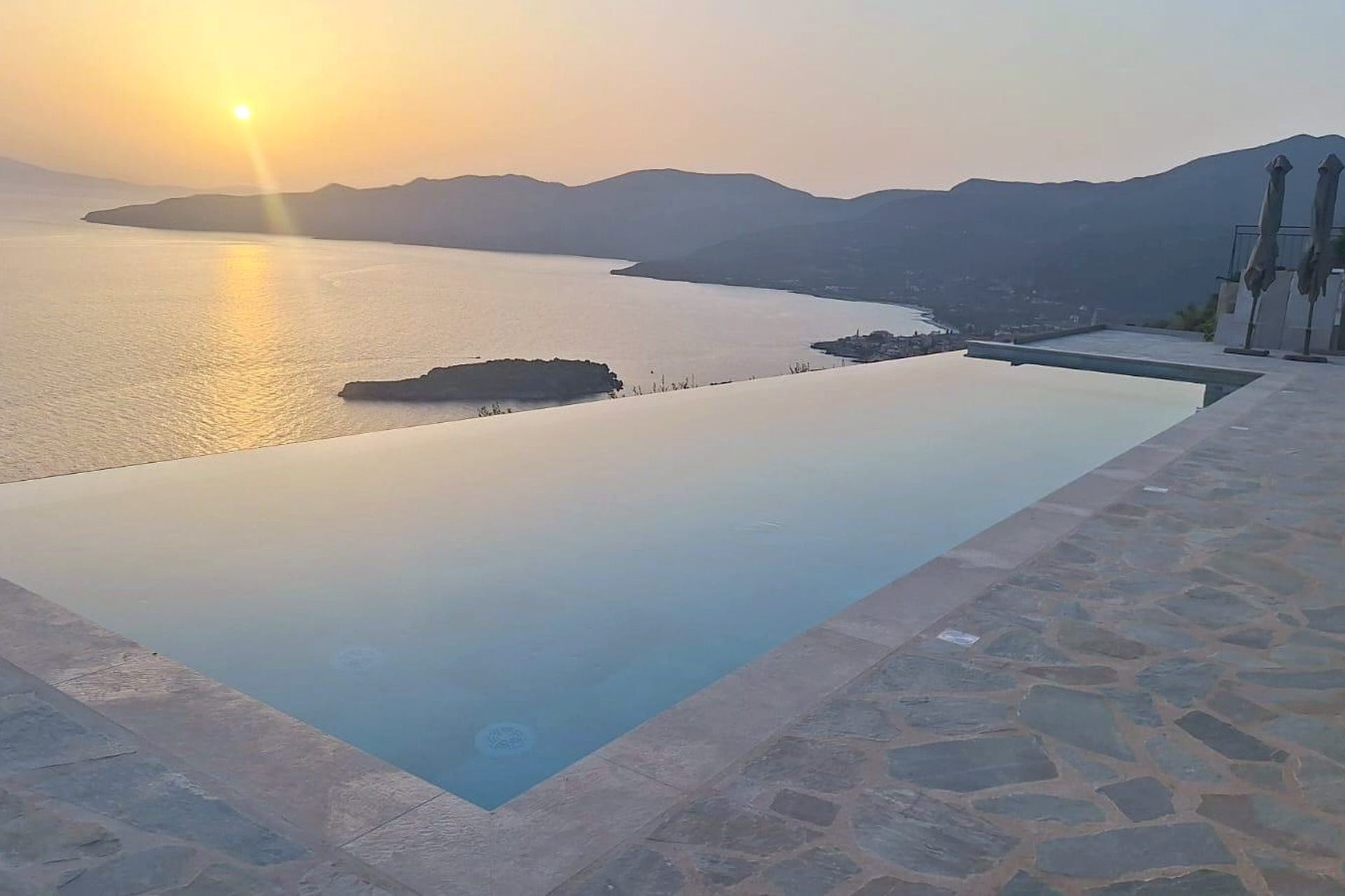 The sun going down over the Messenian gulf, seen along the length of the pool from the terrace.